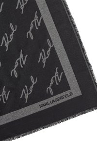 Fular negru cu logo-ul și modelul semnăturii Karl Lagerfeld în nuanțe de gri, cu margine franjurată și design cu bordură. Textură de țesătură moale.