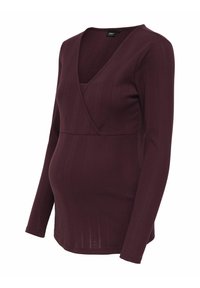 Tehotenský top v tmavobordovej farbe, s výstrihom do V a dlhými rukávmi. Vyrobený z rebrovaného materiálu s priliehavým strihom, ktorý zvýrazňuje brucho.