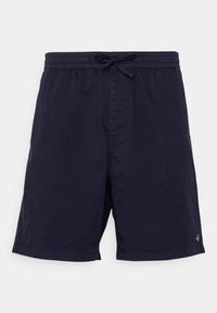 Shorts de bain bleu marine avec une taille élastique, cordon de serrage et poches latérales. Texture lisse avec un design simple et sans motifs visibles.