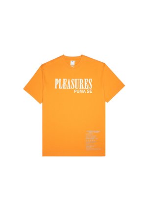 Orange Baumwoll-T-Shirt mit Rundhalsausschnitt, auf der Vorderseite mit weißem Text "PLEASURES" und "PUMA SE" bedruckt, und Pflegehinweisen an der Seite.