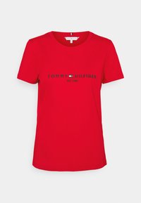 Czerwona bawełniana koszulka z krótkim rękawem, z czarnym napisem "TOMMY HILFIGER EST. 1985" na piersi. Klasyczny okrągły dekolt.