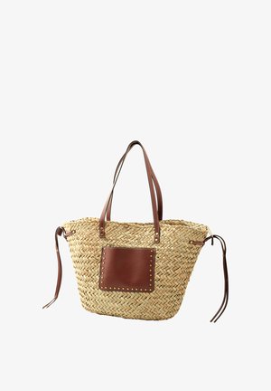 Borsa tote in paglia intrecciata con due manici in pelle marrone, una tasca frontale in pelle marrone con borchie in ottone e laccetti laterali regolabili.