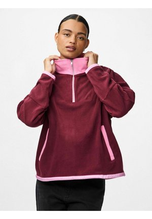 Fleece pulover u boji burgundca s ružičastim naglasima, ovratnik s polu-zipom, bočne džepove i teksturiranu završnu obradu. Ima duge rukave i opušteni kroj.