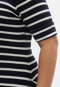 Tengerészkék és fehér csíkos r�övid ujjú felső, puha anyagból készült. Testhez simuló szabású és felhajtott mandzsettás. Oldalt varrásrészlet látható.