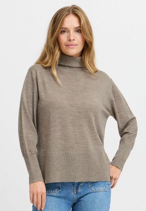 Pull à col roulé marron avec une coupe décontractée et des manches longues, présentant une texture à côtes fines et un ourlet droit, associé à un jean bleu.