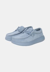 Scarpe slip-on in suede azzurro chiaro con punta arrotondata, cuciture decorative e suole imbottite per il comfort. Presentano un design minimalista.