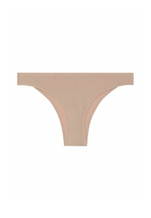 String en beige en matériau doux et élastique avec une texture lisse. Présente un design minimal et des bords sans couture pour plus de confort.