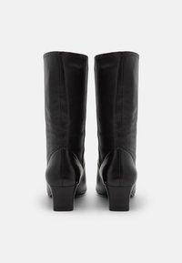 Botas altas de cuero negro con una textura suave, punteras redondeadas y un tacón modesto. Sin patrones visibles ni detalles metálicos.