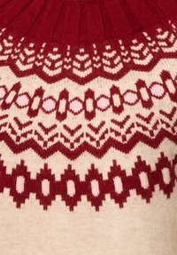 Strickpullover mit einem gerippten roten Halskragen, komplexen roten und rosafarbenen Mustern auf einem cremefarbenen Hintergrund, mit geometrischen und floralen Motiven.