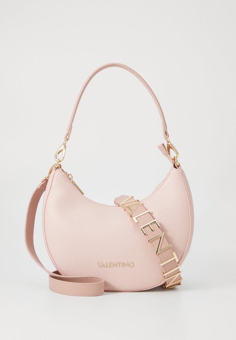 Ružová kožená kabelka s krivkovou siluetou, zlatým kováním a odnímateľným popruhom so značkou "VALENTINO" napísanou veľkými písmenami.