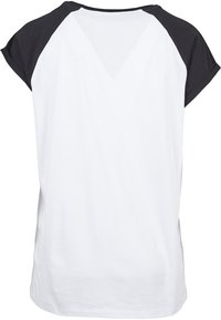 Camiseta blanca con mangas raglán negras. Material de algodón suave, de manga corta, con cuello redondo y un diseño de corte relajado.