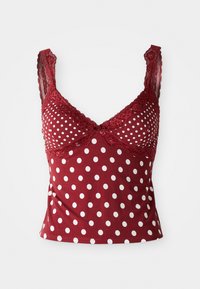 Red sleeveless top with white polka dots, lace trim on straps and neckline, and a small rose detail at the center front.