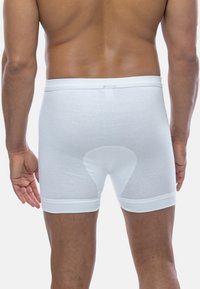 White cotton boxer briefs with a smooth texture, elastic waistband, and a reinforcement panel on the backside for added support.