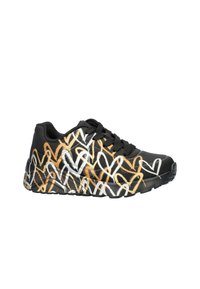 Zapatilla deportiva negra con un patrón de corazones coloridos en blanco, naranja y amarillo. Superficie texturizada con cordones negros y suela de goma.