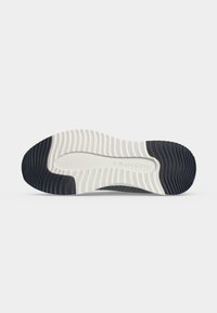 Semelle de chaussure avec motif ondulé noir et blanc, avec la marque "Marc O'Polo" au centre.