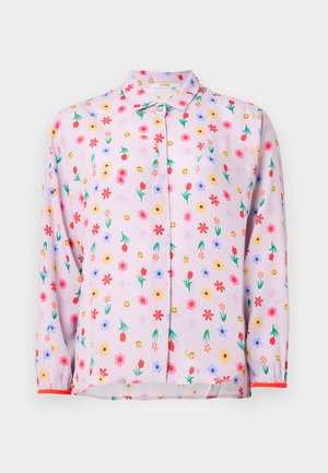 Hellrosa Bluse mit floralem Muster aus roten, gelben und blauen Blumen, lächelnden Gesichtern und einer Knopfleiste vorne. Lange Ärmel mit roten Akzenten.