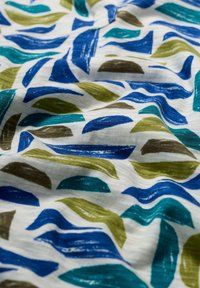 Mintás textil, amely kék, zöld és barna ívelt formákat ábrázol egy fehér háttéren; sima tapintású, látható ecsetvonásokkal.