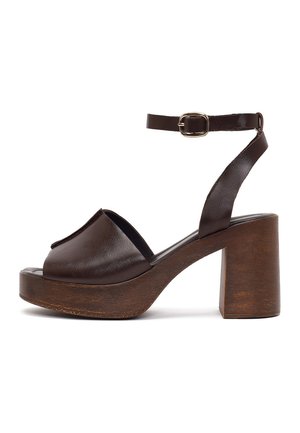 Sandalia de plataforma de cuero marrón con puntera abierta, tira al tobillo con hebilla dorada y tacón grueso de bloque de madera.