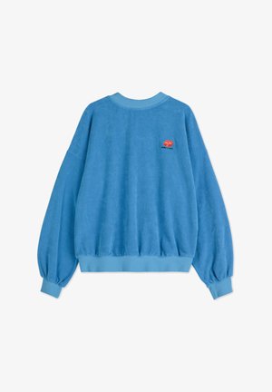 Blauwe sweater met een zachte textuur, ballonmouwen, geribbelde mouwen en een klein geborduurd oranje gezichtlogo op de achterkant.