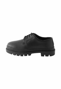 Chaussure en cuir noir avec un bout rond, un laçage, une tige texturée et une semelle en caoutchouc robuste dotée d'une profonde rainure pour l'adhérence.