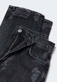 Vaqueros de mezclilla negra con desgaste visible y bordes deshilachados. Cuenta con cremallera, cierre de botón y diseño estándar de cinco bolsillos.