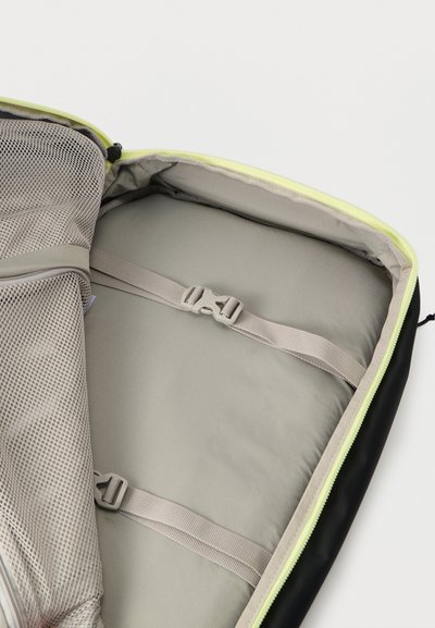 Μαύρη τσάντα με φερμουάρ σε λαμπερό πράσινο χρώμα λάιμ, διαθέτει γκρι εσωτερικό και δίχτυνο τσεπάκι, με ρυθμιζόμενους ιμάντε ς για ασφαλή συγκράτηση των αντικειμένων.
