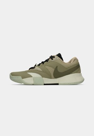 Niedrig geschnittener, olivgrüner und beiger Sportschuh mit schwarzen Schnürsenkeln, Nike-Swoosh und strukturierten Lagen auf einem weißen Hintergrund.