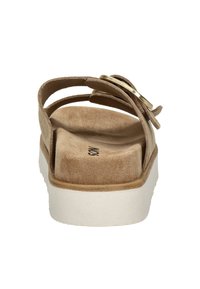 Beige suède sandaal met drie dunne banden en een goudkleurige gesp. Voorzien van een witte plateauzool en een gestructureerde binnenzool.