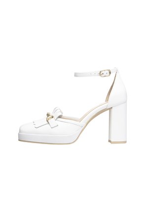 Weißer Schuh mit hohen Absätzen, dicken Blockabsätzen, abgerundeter Zehenform und Knöchelriemen. Mit einer Schleifendekoration und goldenen Hardware-Akzenten.