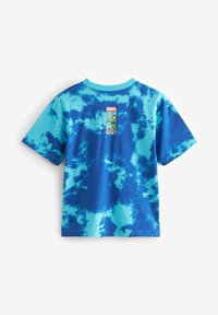 Zila tie-dye T-kreklu ar Marvel zīmolu augšējā aizmugurē. Izgatavots no kokvilnas, tam ir īsas piedurknes un apaļš dekoltē.
