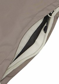 Beige wasserdichte Jacke mit Reißverschlussdetail, das ein weißes Futter und eine schwarze Netzinnentasche zeigt. Der Stoff hat eine glatte, weiche Textur.