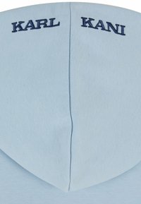 Light blue hooded sweatshirt featuring embroidered "KARL" on the left and "KANI" on the right, made of soft, textured fabric.