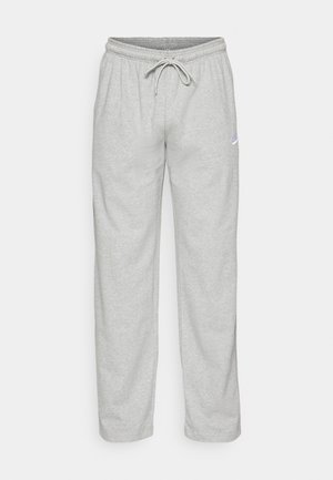 Calças de sweats cinza claro, feitas de um tecido suave. Apresentam uma cintura elástica com cordão e o logótipo da Nike em preto na coxa esquerda.
