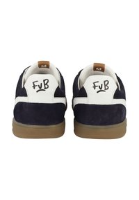 Mörkblå mockaskor med vita läderdetaljer, brun logotags på hälen och gummisulor. Har "FuB"-logotyp på baksidan.