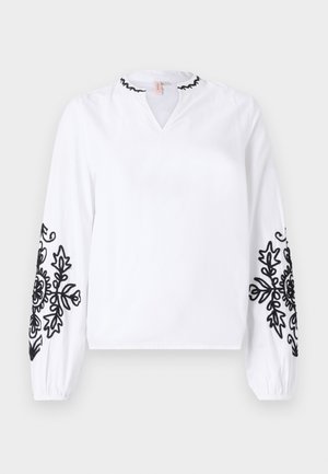 Bela bluzica z dolgimi rokavi, ki ima črno cvetlično vezenje na rokavih in V-izrez s naborkom. Narejena je iz lahko tkanine.