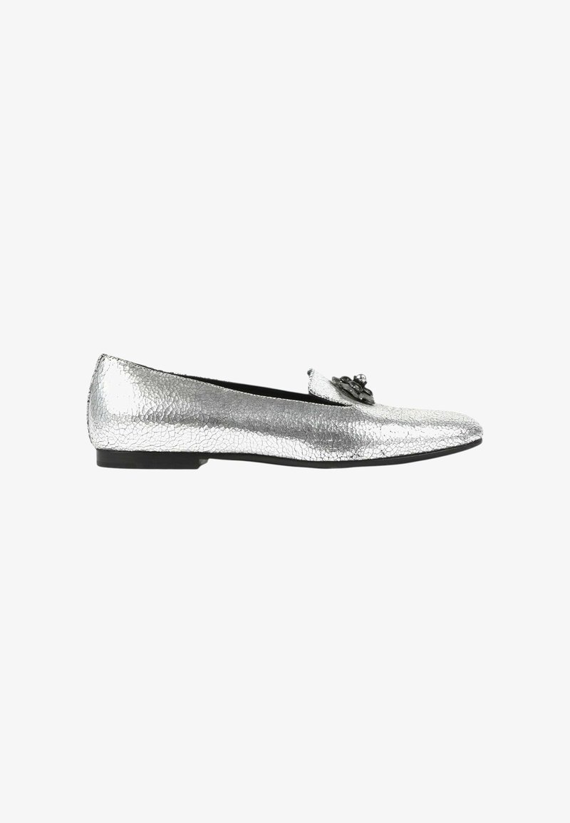 Chaussure plate argentée avec texture craquelée et semelle noire, ornée d'un nœud noir décoratif à l'avant.