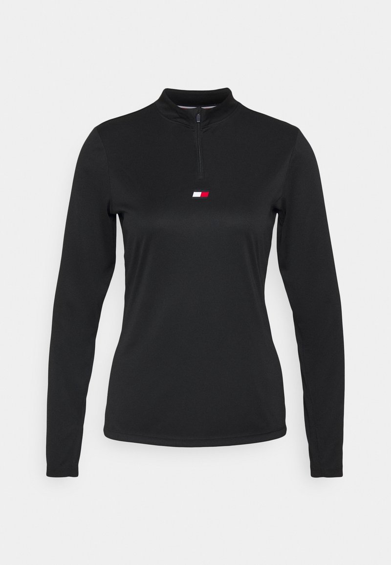 Black long-sleeve pullover with a zip front, featuring a small red and white logo on the chest. Made from smooth, stretchable fabric.
