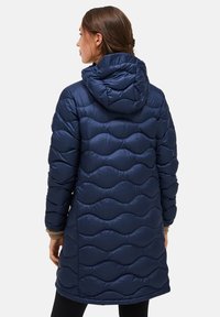 Marineblauwe gewatteerde jas met capuchon, voorzien van een geweven golfpatroon, lange mouwen en een middellange snit. Glad, glanzend oppervlak.