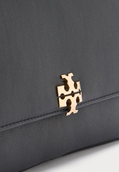 Black textured leather with a gold metal puzzle piece-shaped clasp and visible horizontal stitching detail.