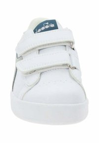Sneaker bianco con cinturini in Velcro, superiore in sintetico liscio e suola piatta in gomma. Le caratteristiche includono cuciture minime e un'etichetta blu del logo.