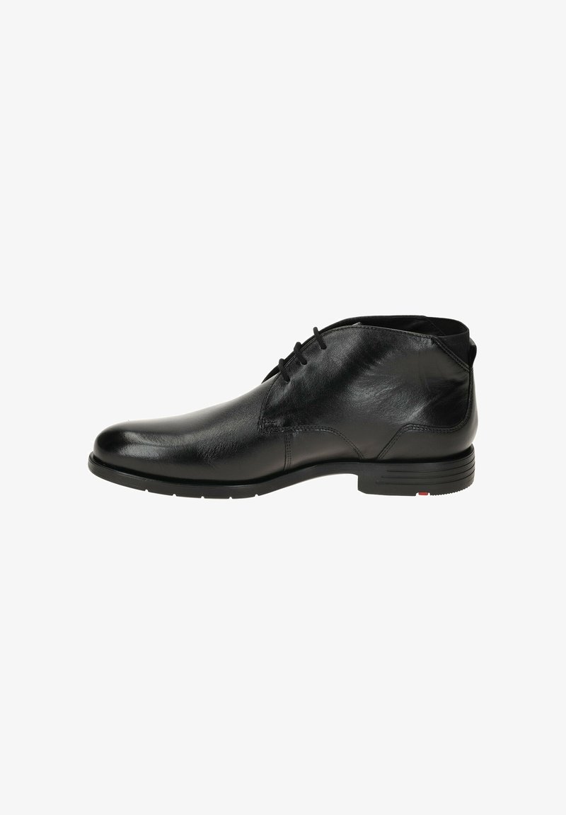 Chaussure de ville noire en cuir pour homme, à la cheville, avec lacets et petit talon, vue de côté sur fond blanc.