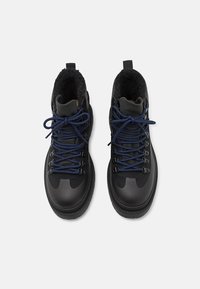 Black hiking boots with a smooth leather exterior, blue laces, and a furry lining. Features metal eyelets and a textured rubber sole.