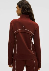 Giacca sportiva bordeaux con colletto alto, dettagli di cucitura a contrasto e design fitted. Presenta un piccolo logo sul retro.