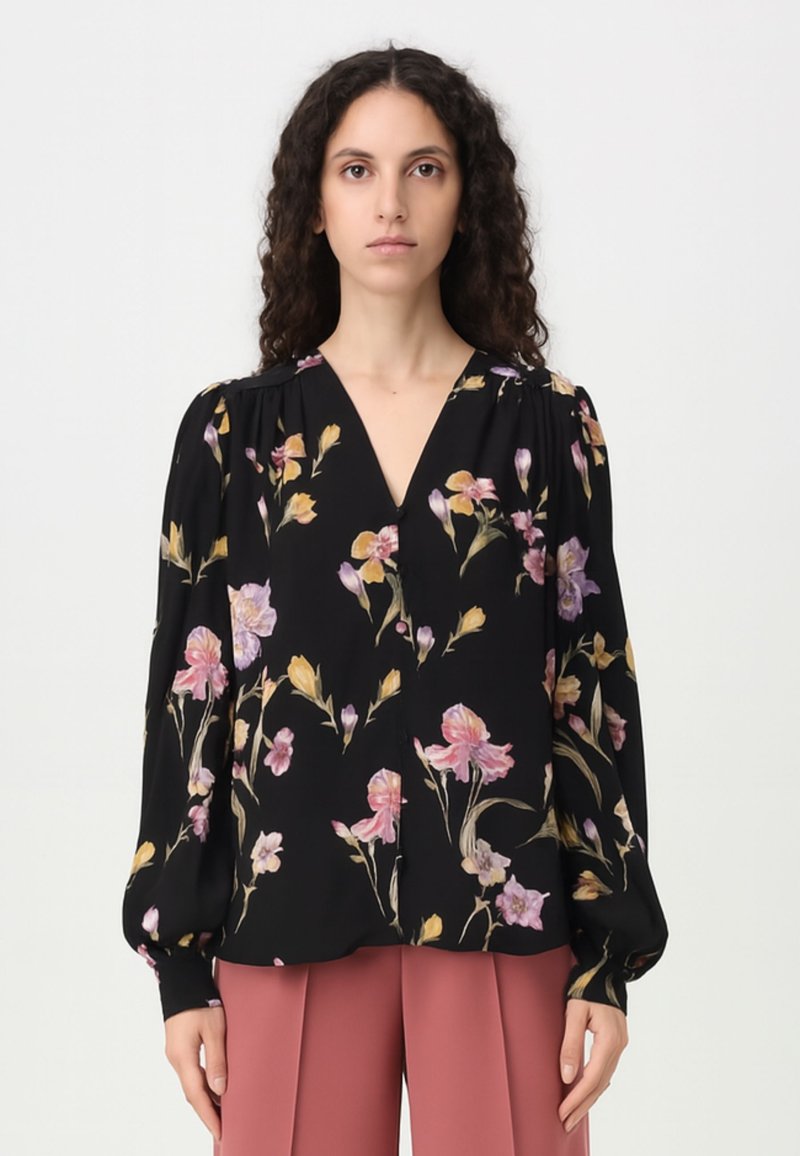 Blusa nera con stampa floreale in rosa, giallo e viola. Presenta un colletto a V, maniche a sbuffo e una vestibilità comoda. Realizzata in tessuto leggero.