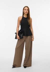 Černý bezramínkový peplum top spárovan�ý s hnědými kalhotami s vysokým pasem a širokými nohavicemi. Doplňky zahrnují černou kabelku a špičaté podpatky.