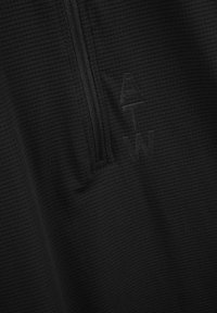 Czarna bluza zapinana na zamek, z teksturowaną powierzchnią, posiadająca półdługą suwaki oraz wytłoczone logo na tkaninie.