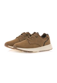 Zapatillas de cuero marrón con una textura suave, suela blanca y detalles en negro. Cuentan con puntera redonda y sistema de cordones tradicional.