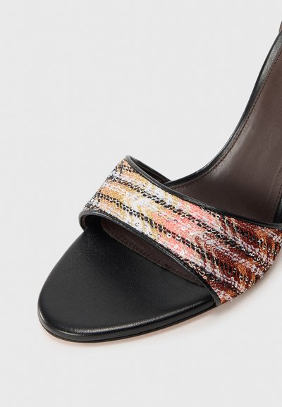 Svart öppen tå sandal med en strukturerad rem med metalltrådar i guld, rosa och svart. Slät lädersula och böjd form.