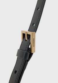 Sort lærbelte med firkantet spenne i gulltonet metall, justerbare hull og en glatt tekstur. Merket med "ALLSAINTS."