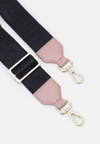 Cinghia regolabile realizzata in tessuto intrecciato nero con testo in rilievo, estremità in pelle rosa, hardware color oro e ganci per il fissaggio.